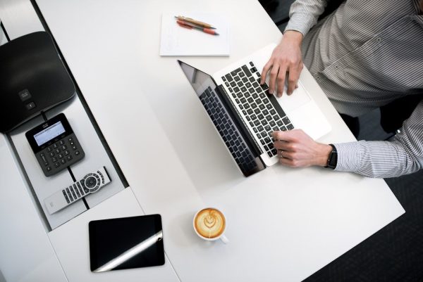 a person sitting at a desk working on buying a business at his computer