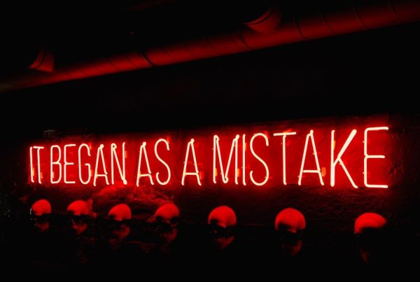 a neon sign saying 'it began as a GST mistake'