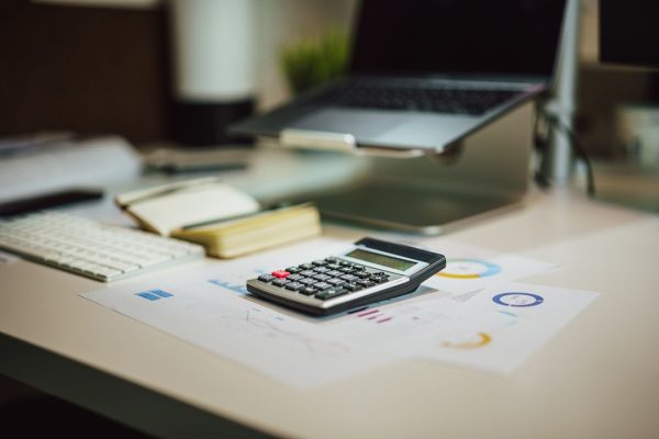a calculator and piece of paper working out taxes