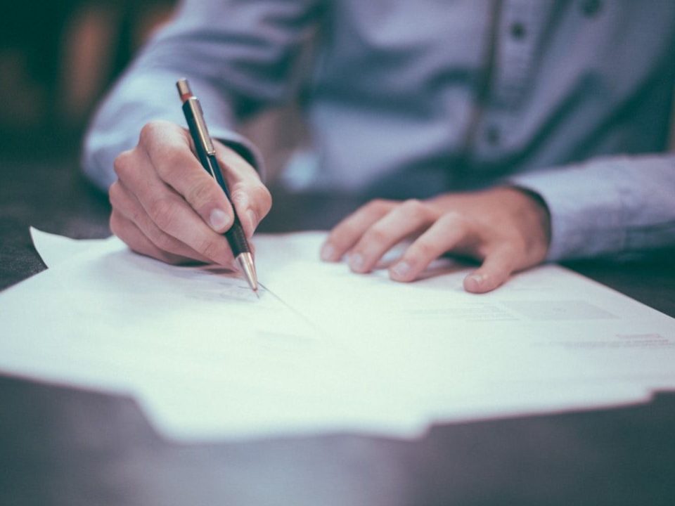 photo of man signing off invoices for payment