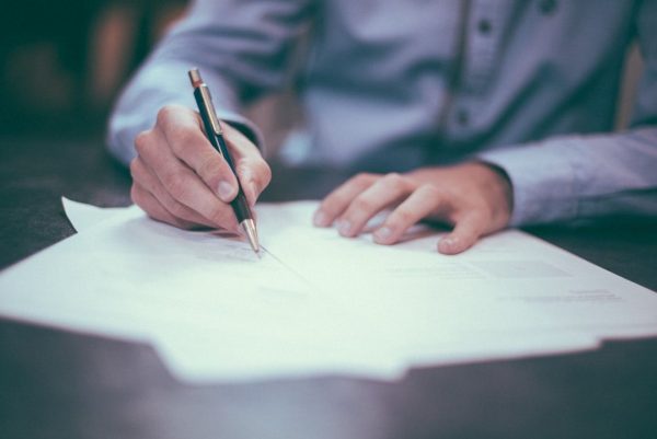 photo of man signing off invoices for payment