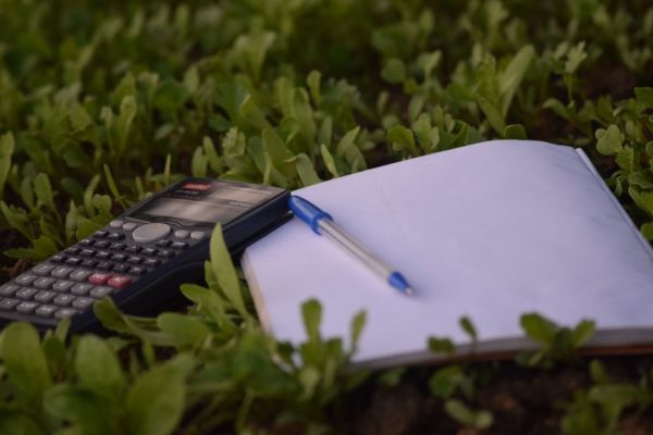 a calculator pen and paper to calculate business ratios