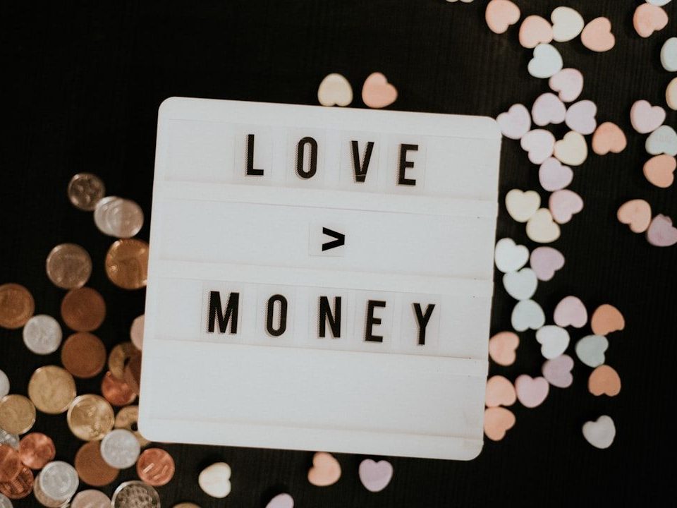 A sign saying "love money" representing a payment for an individual Shareholder Salary vs PAYE