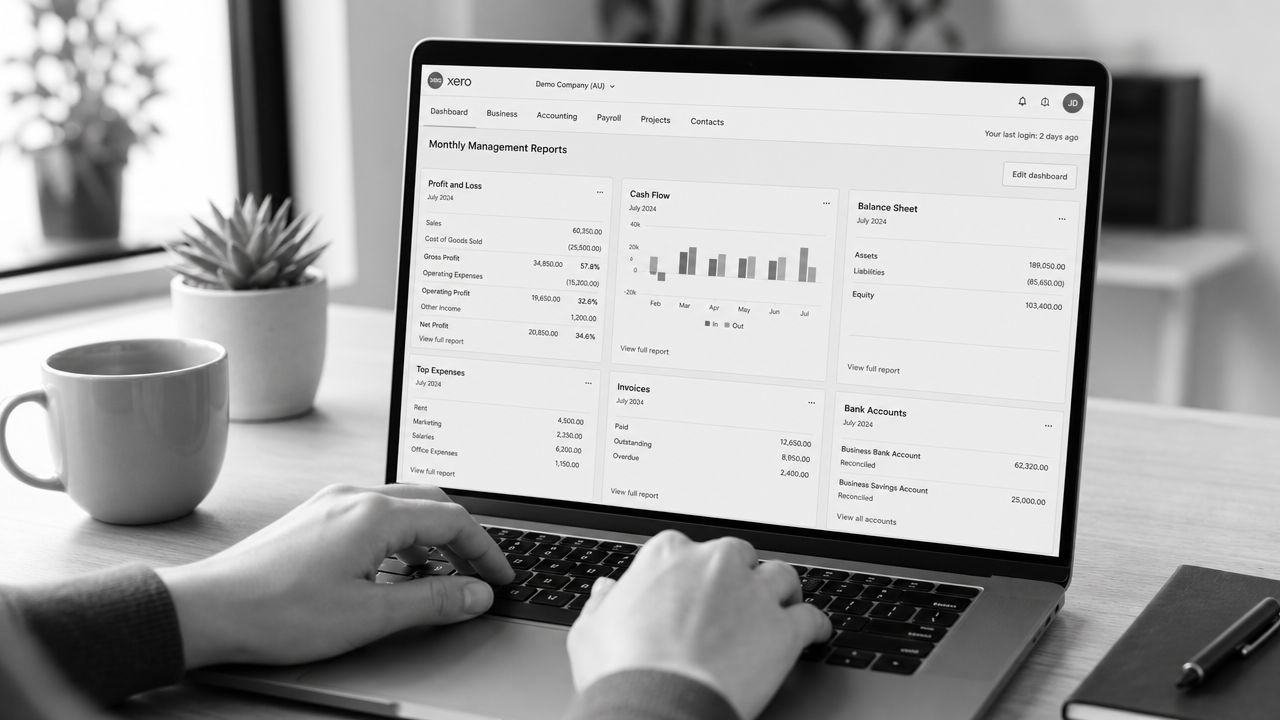 A person working on a laptop displaying a financial dashboard with management reports and company charts.